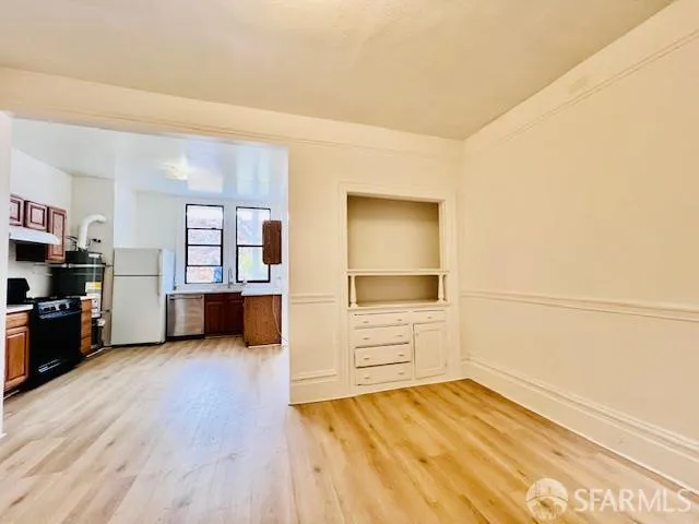 a view of a kitchen with wooden floor and a refrigerator