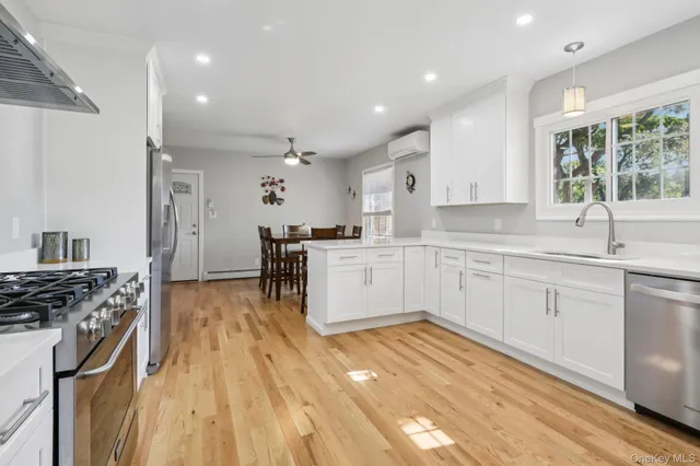 a kitchen with granite countertop white cabinets white stainless steel appliances with a sink and dishwasher