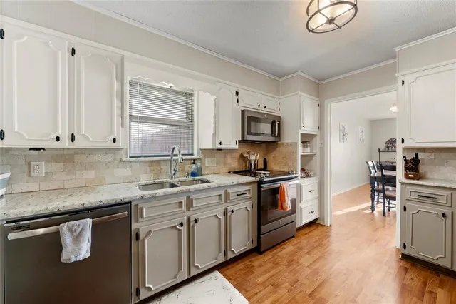 a kitchen with stainless steel appliances granite countertop a stove top oven a sink dishwasher and a microwave oven on the blue kitchen countertops
