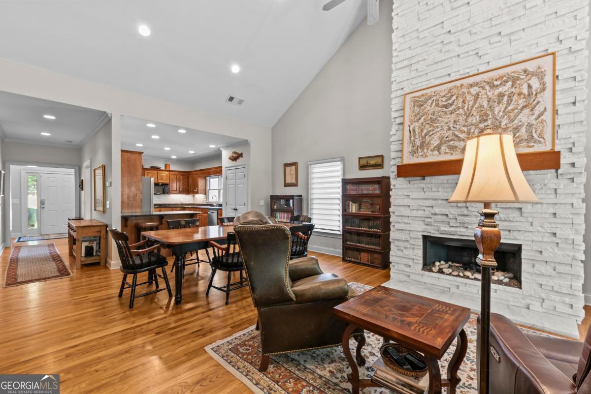 1540 Vintage Club Road Greensboro, GA 30642 - Photo 38 of 71 a living room with furniture a fireplace and a kitchen view
