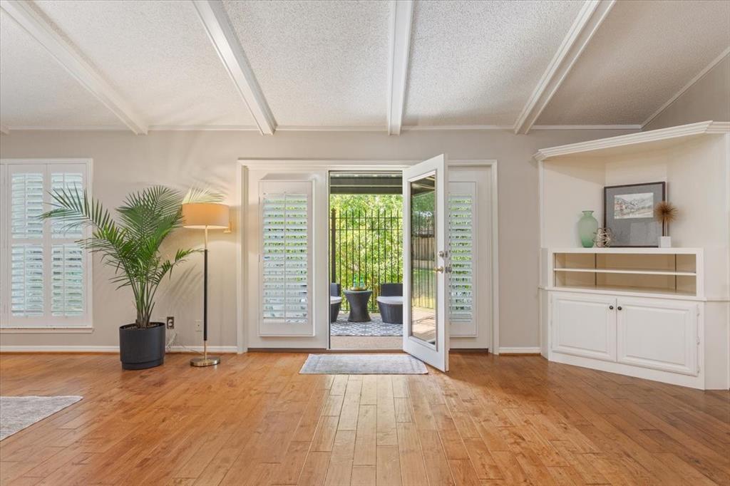 4108 Old Mill Road Waco, TX 76710 - Photo 11 of 39 Spacious open-concept living area that opens to a covered back patio featuring coffered ceiling with recessed lighting, hardwood flooring throughout, and a custom built-in