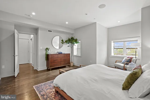 a bedroom with a bed a mirror and furniture