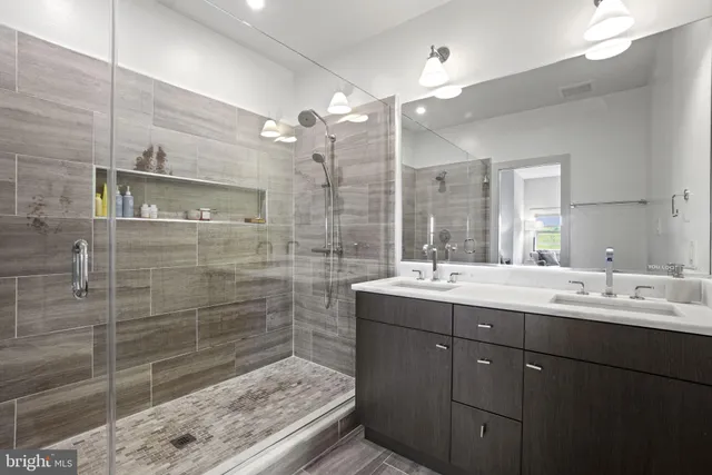 a bathroom with a double vanity sink mirror and shower