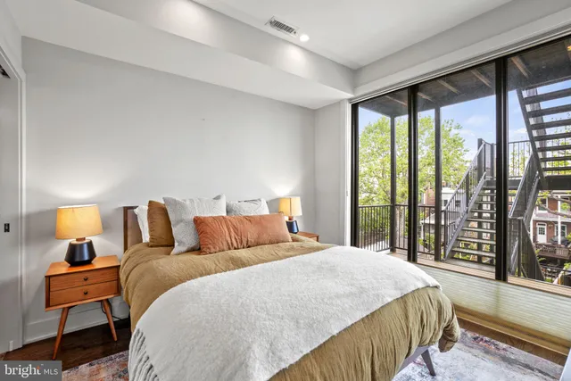 a bedroom with a bed and a large window