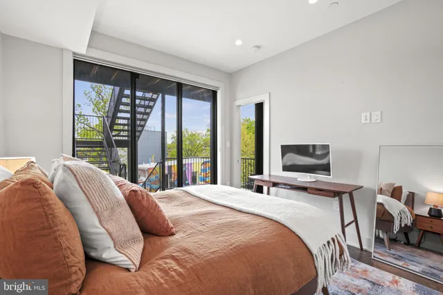 a bedroom with a bed and large windows