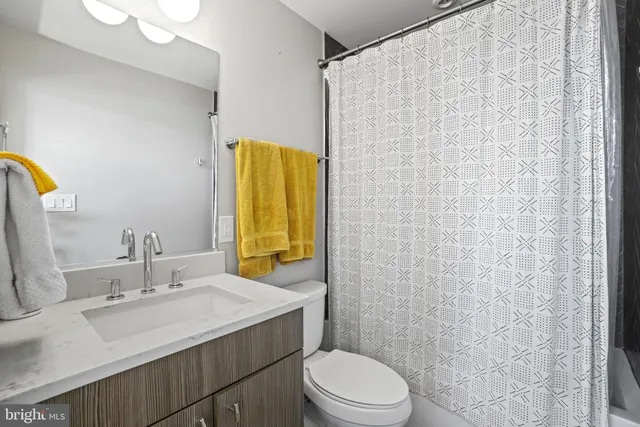 a bathroom with a sink a toilet and shower curtain