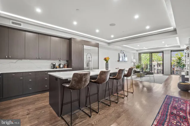 a view of kitchen with granite countertop lots of counter top space and living room