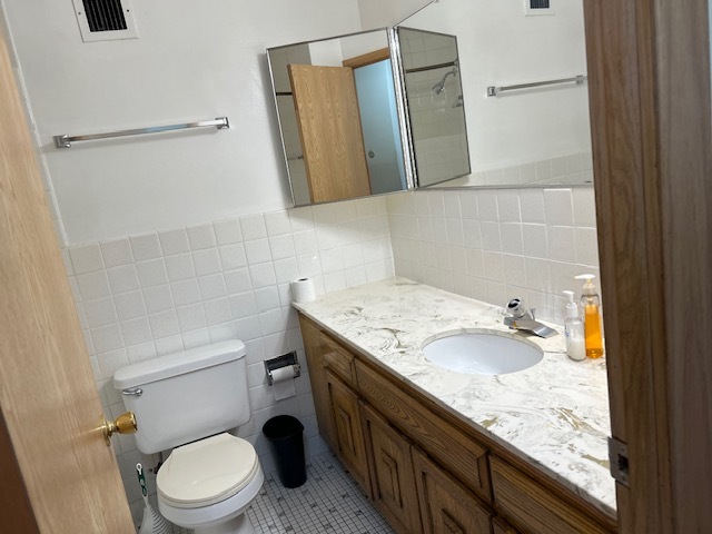 5915 West Gunnison Street, Unit 2F Chicago, IL 60630 - Photo 7 of 10 a bathroom with a granite countertop toilet sink and mirror