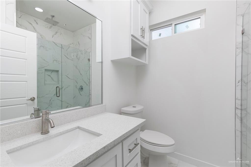 915 Pecan Street Alton, TX 78573 - Photo 14 of 22 a bathroom with a sink a toilet and shower