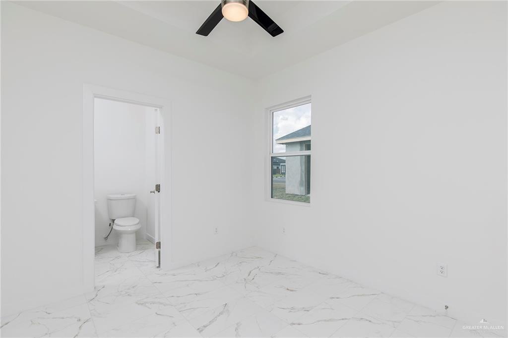 915 Pecan Street Alton, TX 78573 - Photo 15 of 22 an empty room with a white walls and ceiling fan