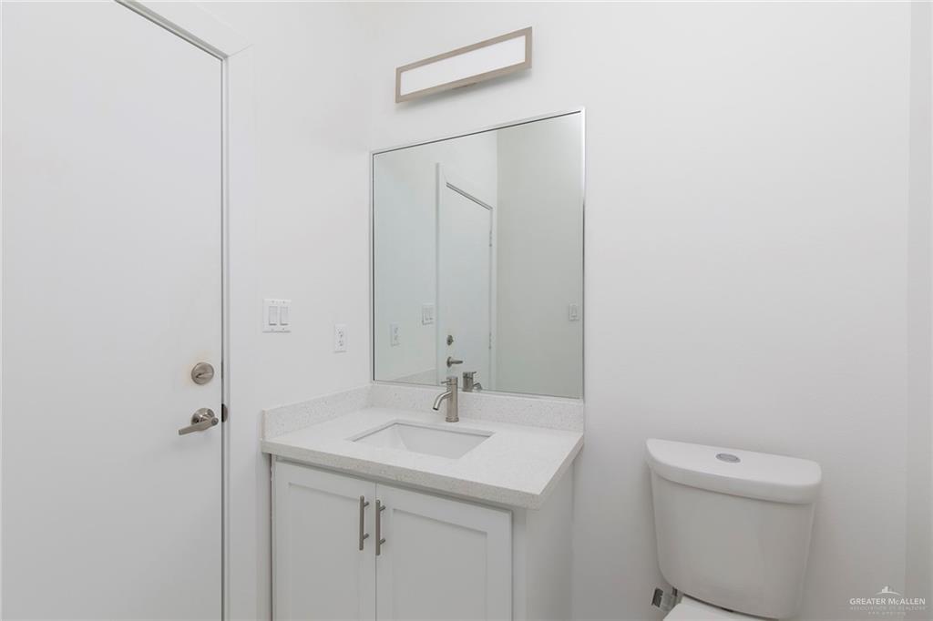915 Pecan Street Alton, TX 78573 - Photo 16 of 22 a bathroom with a sink a toilet and a mirror