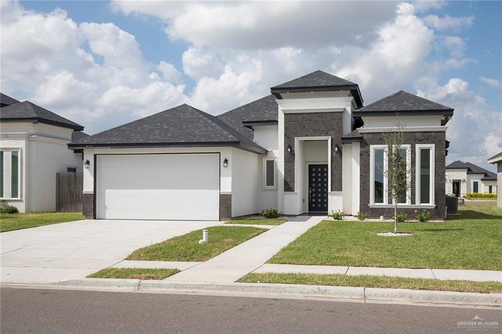 915 Pecan Street Alton, TX 78573 - Photo 2 of 22 a front view of a house with a yard and garage