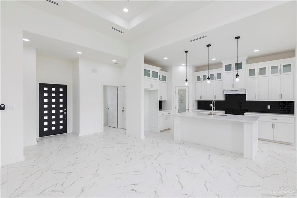 915 Pecan Street Alton, TX 78573 - Photo 4 of 22 a large white kitchen with stainless steel appliances kitchen island granite countertop a refrigerator and a stove top oven