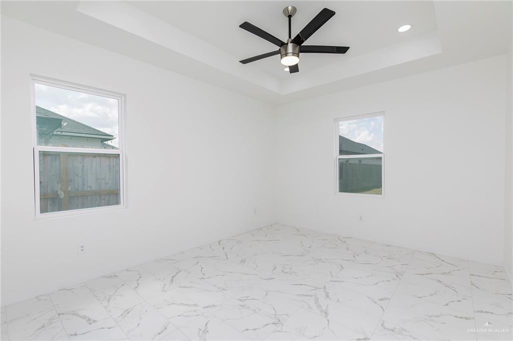 915 Pecan Street Alton, TX 78573 - Photo 10 of 22 an empty room with a window and a fan