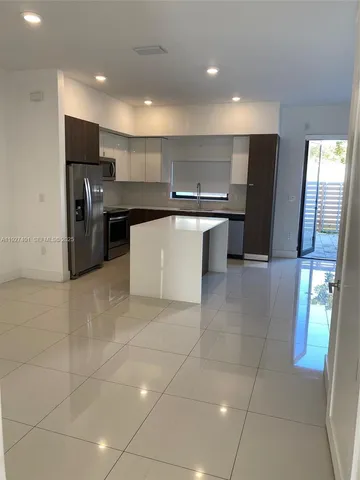 a kitchen with stainless steel appliances a refrigerator sink and microwave