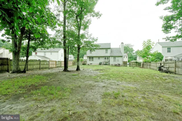 a view of a house with backyard and a tree