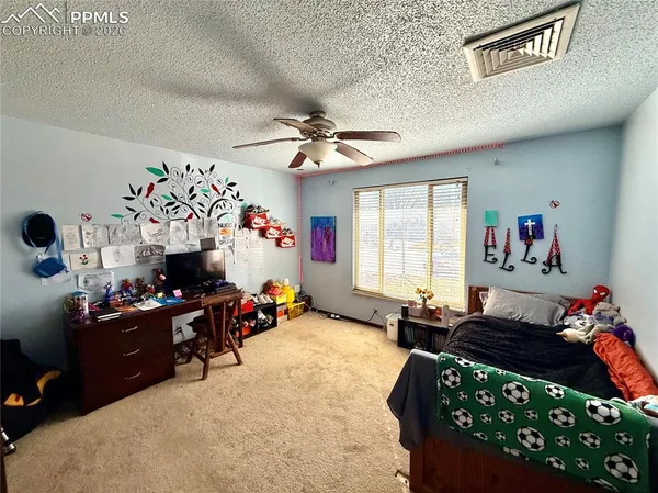 a bed room with a bed a dresser and a window
