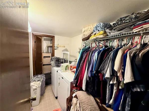 a view of walk in closet with clothes and shoes