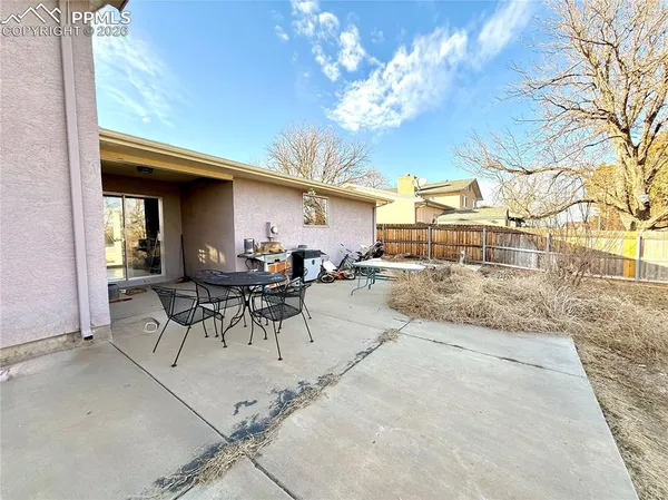 a view of a patio with table and chairs and potted plants