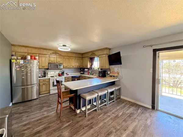 a kitchen with stainless steel appliances granite countertop a lot of cabinets and wooden floor