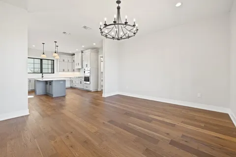 a large kitchen with stainless steel appliances granite countertop a stove a sink dishwasher and a refrigerator with wooden floor