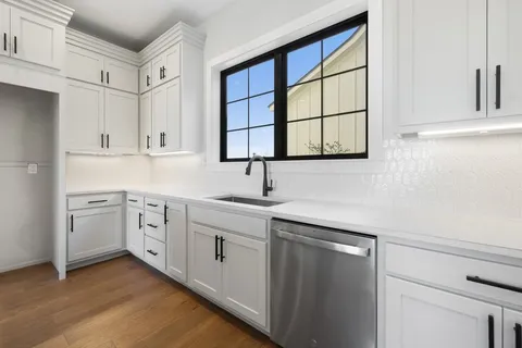a kitchen with cabinets stainless steel appliances and wooden floor