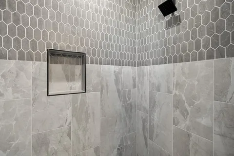 a bathroom with a granite countertop toilet sink and mirror