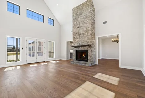 a view of empty room with fireplace and wooden floor