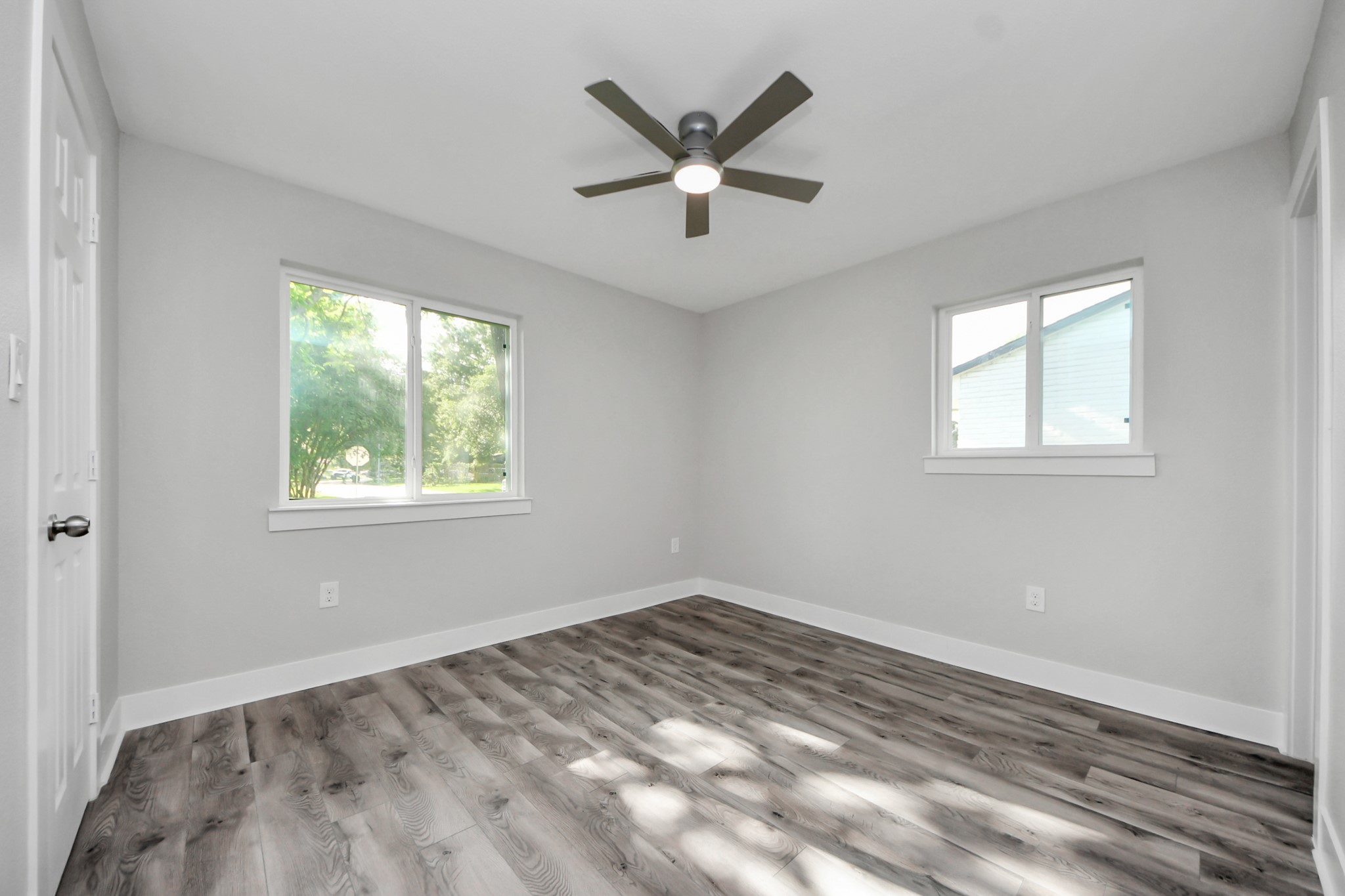 15318 Corsair Road Houston, TX 77053 - Photo 16 of 23 an empty room with wooden floor ceiling fan and windows