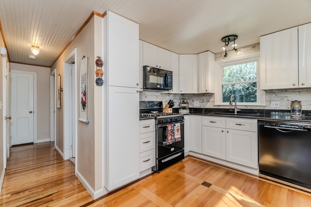 57 Lumae Street Springfield, MA 01119 - Photo 16 of 36 a kitchen with stainless steel appliances granite countertop a refrigerator a sink dishwasher a stove and white cabinets with wooden floor