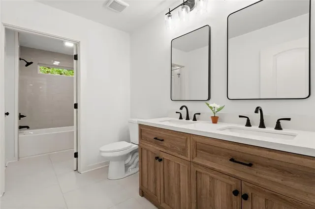 a bathroom with a double vanity sink toilet and shower