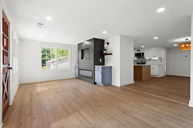 a view of kitchen with stainless steel appliances kitchen island wooden floors and center island