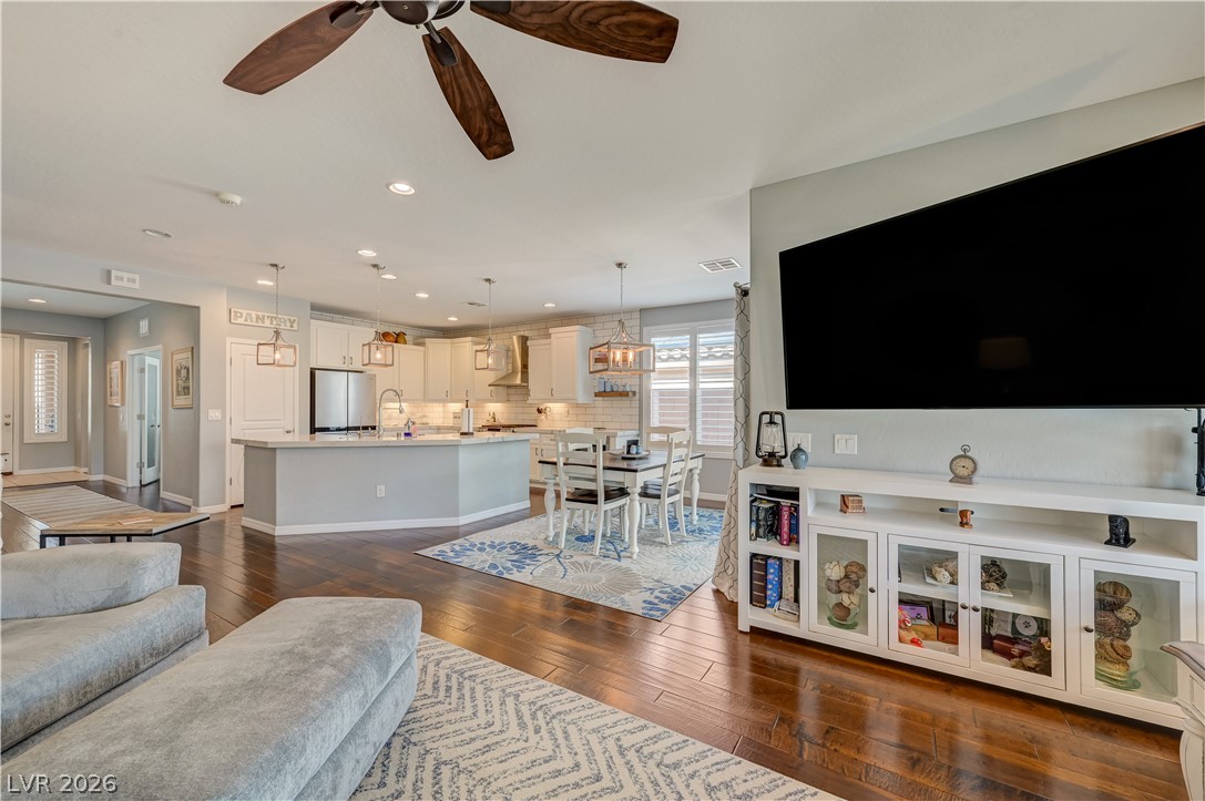 7049 Motley Road Las Vegas, NV 89178 - Photo 22 of 61 Rich hardwood flooring anchors this airy open-concept space seamlessly connecting the living and dining areas.