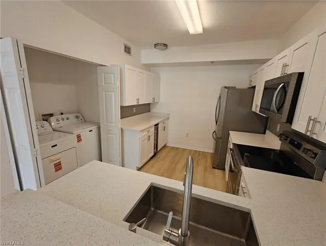 a kitchen with a refrigerator and a stove top oven