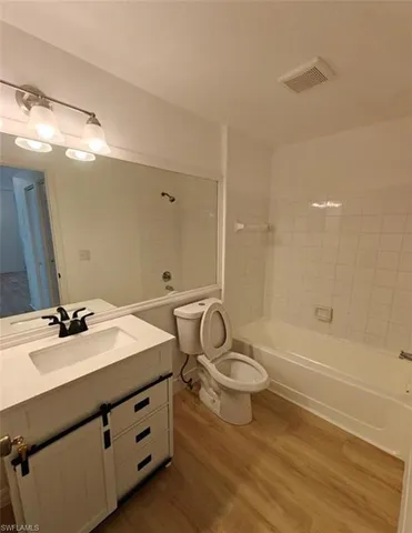 a bathroom with a double vanity sink toilet mirror and bathtub