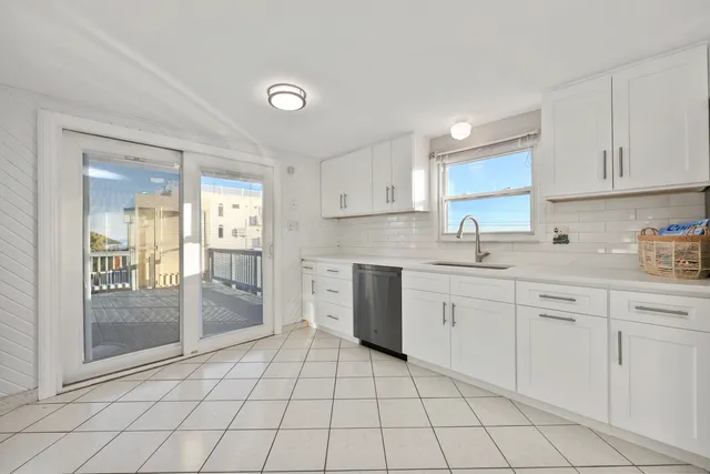 a kitchen with white cabinets a sink and appliances