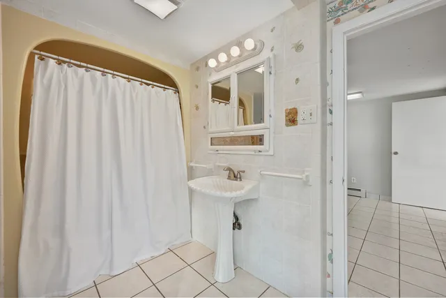 a bathroom with a sink a mirror and a shower