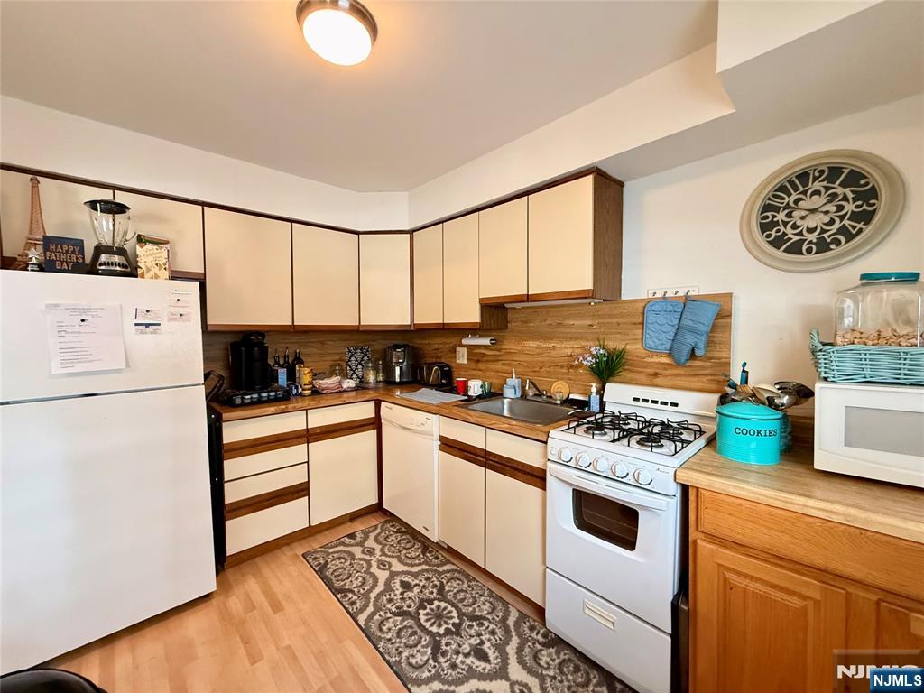 1241 Valley Road, Unit 1241A Wayne, NJ 07470 - Photo 11 of 11 a kitchen with a refrigerator a stove a microwave and cabinets