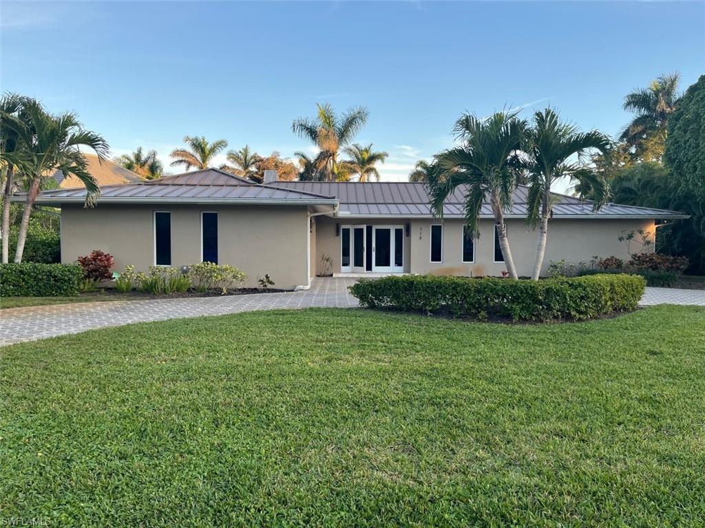 718 Old Trail Drive Naples, FL 34103 - Photo 3 of 18 a front view of a house with a garden and plants