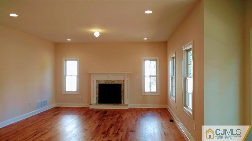 2030 Oak Tree Road Edison, NJ 08820 - Photo 12 of 33 an empty room with wooden floor fireplace and windows