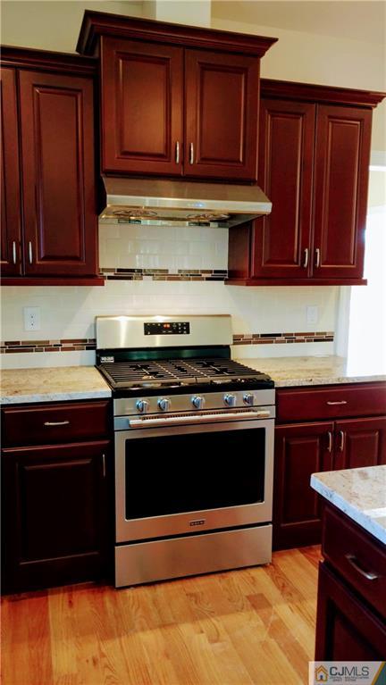 2030 Oak Tree Road Edison, NJ 08820 - Photo 7 of 33 a kitchen with wooden cabinets and a stove top oven