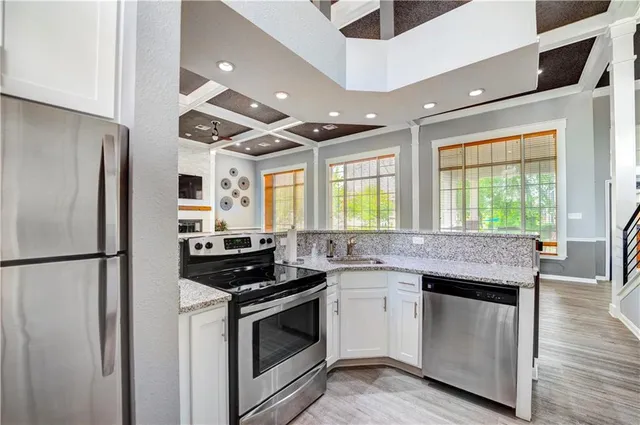 a kitchen with stainless steel appliances kitchen island granite countertop a stove a sink and a refrigerator
