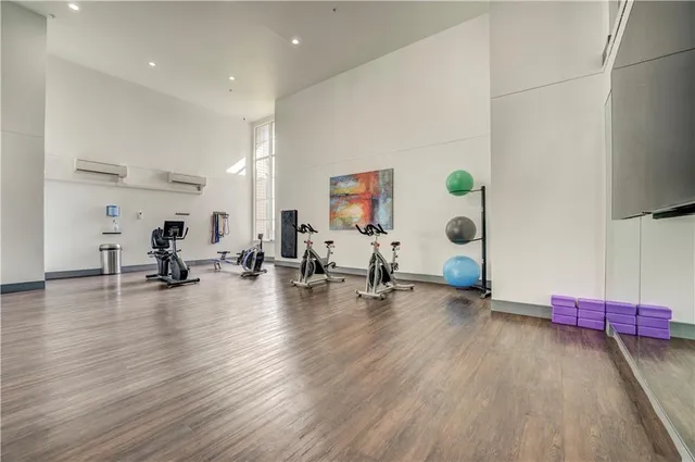 a view of a room with gym equipment and wooden floor