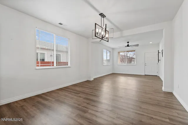 a view of empty room with wooden floor and window