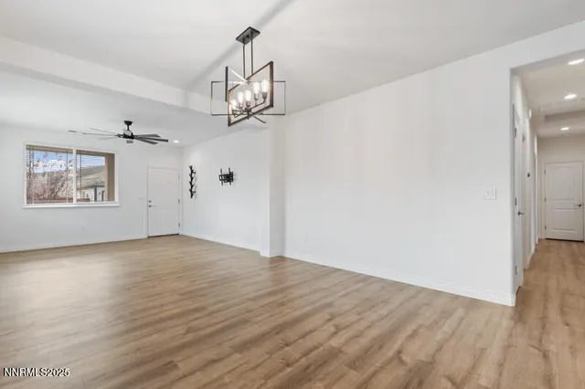 a view of empty room with wooden floor and window