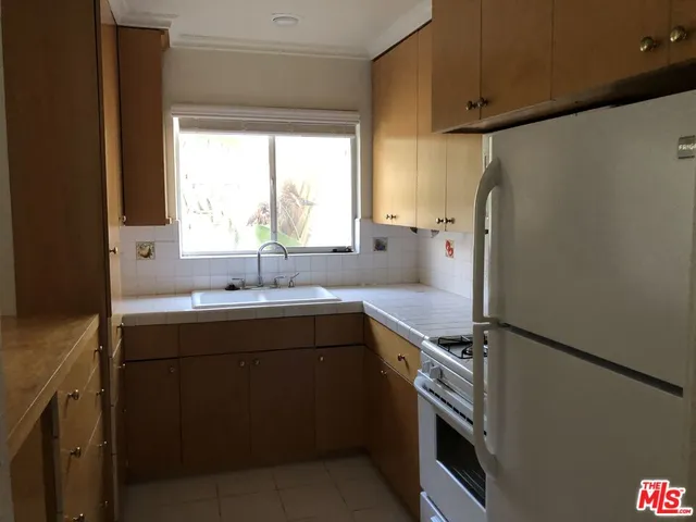 a kitchen with a sink a refrigerator and window