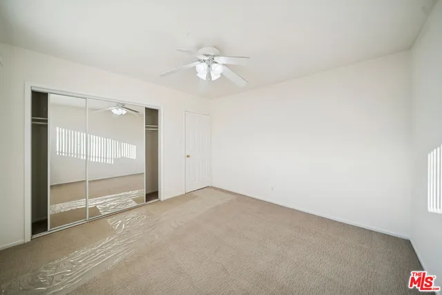 an empty room with fan and windows