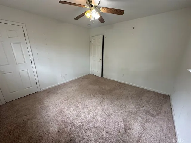 an empty room with a chandelier fan