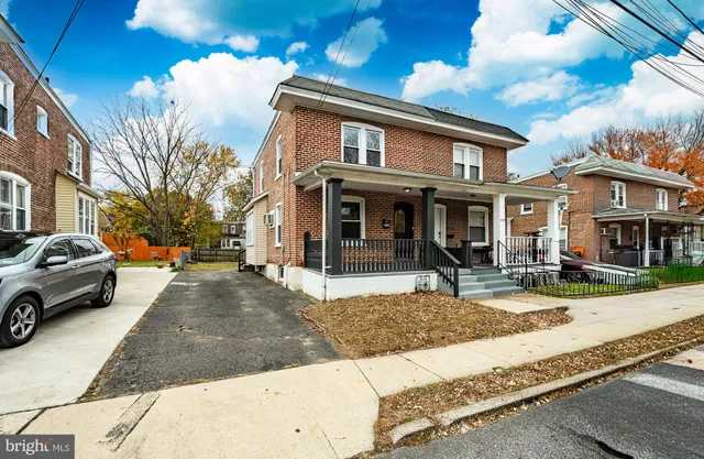 a view of a white house with large windows next to a road