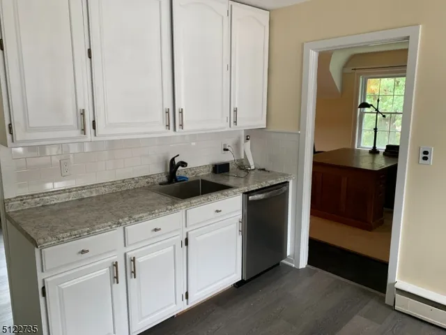 a kitchen with stainless steel appliances granite countertop white cabinets and sink